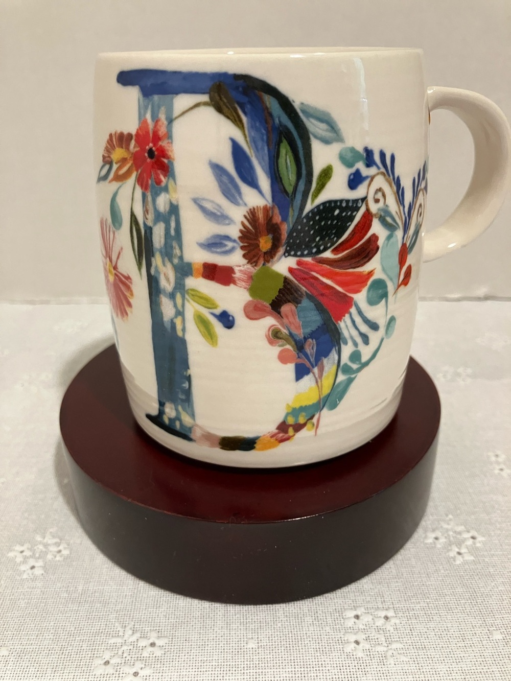Anthropologie White Ceramic Mug with a Blue B & Multicolor Floral Design.